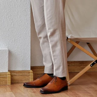 Homme portant des chaussures Oxford en cuir, soulignant le style professionnel et chic.