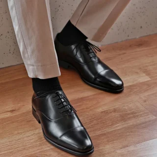 Homme portant des chaussures Oxford en cuir, soulignant le style professionnel et chic.