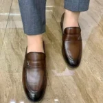 Homme portant des chaussures en cuir souple, combinant confort et style au quotidien.