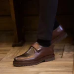 Mocassins à bride motif python portés par un homme