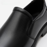 Détail du cuir lisse et brillant des chaussures noir Royal Outwear.